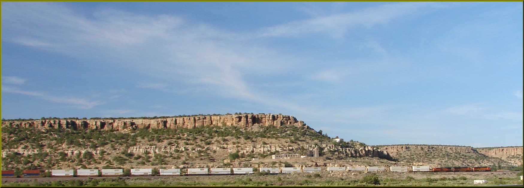 A freight train crossing the New Mexico desert under a wide sky
