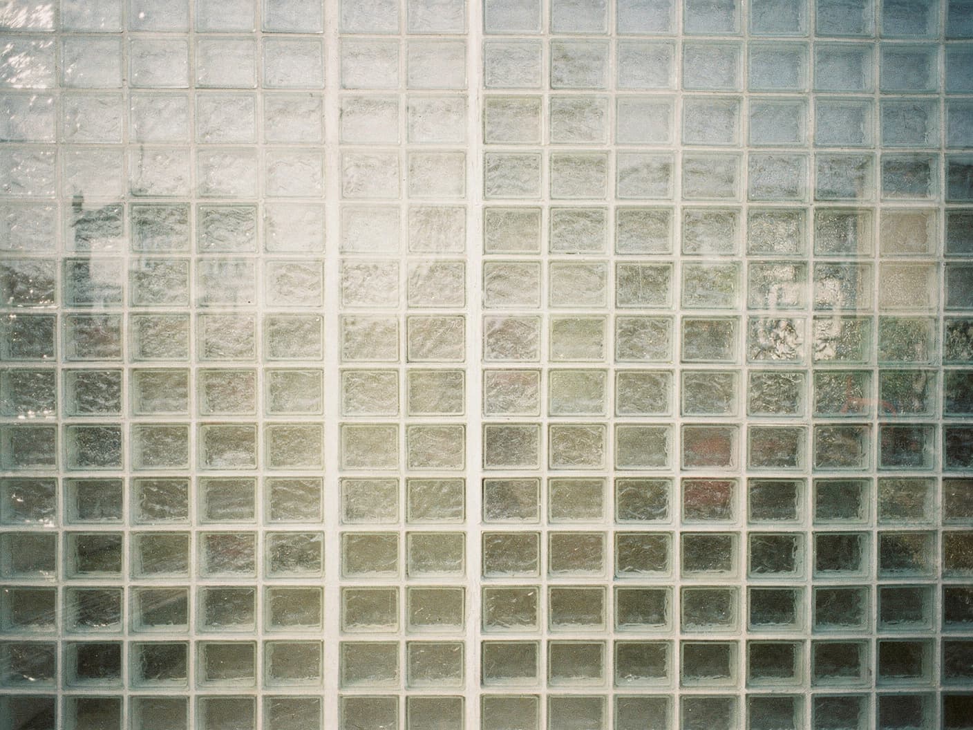 A modernist architectural wall of square glass blocks in soft natural daylight
